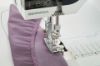 Close-up of Coverstitch/Compensating Foot #C12 being used to topstitch fabric on a Bernina L 890 overlocker.