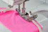 Close-up of Bernina Elasticator Foot #L14 sewing elastic onto fabric on a sewing machine.