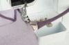 Close-up of Bernina Double Fold Binder #C21 applying bias binding to fabric on a Bernina L 890 overlocker.